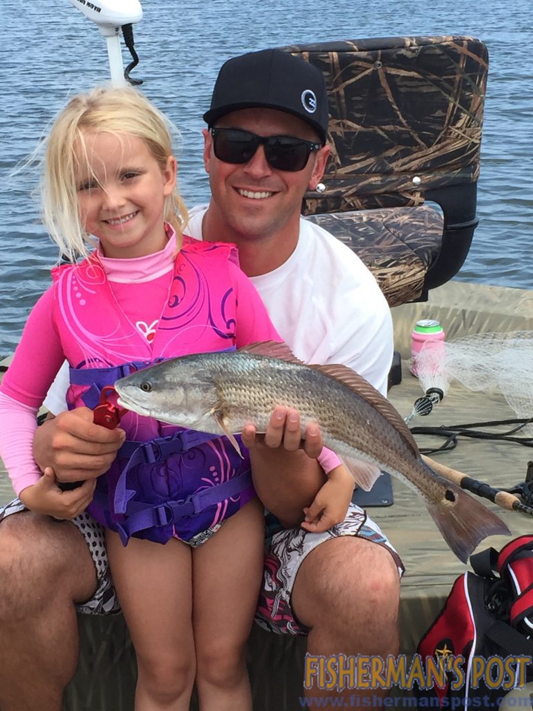 Madison and Jeramie Pawloski with Madison's first redfish, hooked on a jig in a marsh near Swansboro.