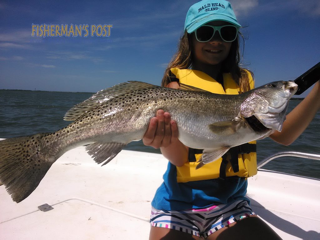 Cameron Ellis, of Arlington, VA, with a gator speckled trout that bit a live bait near Bald Head Island while she was fishing with Capt. Greer Hughes of Cool Runnnings Charters.