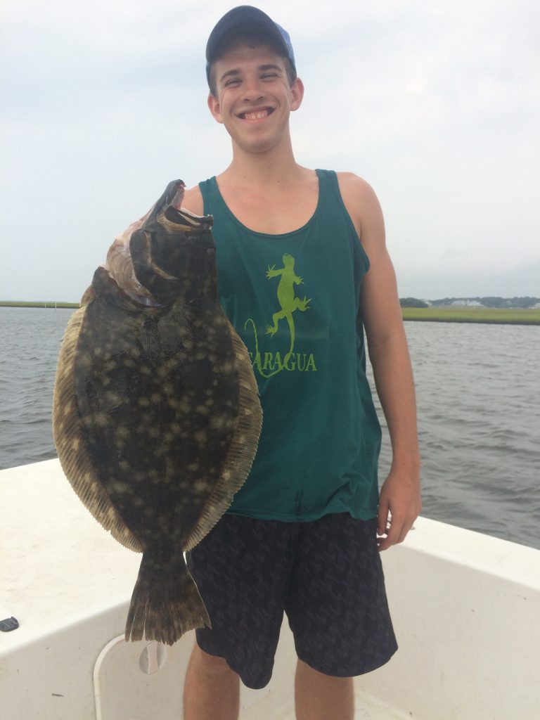 Sam Killenberk, of Chapel Hill, NC, with a 7.1 lb. flounder that bit a live finger mullet in 2' of water in a Swansboro marsh. He was fishing with Capt. Rob Koraly of Sandbar Safari Charters.