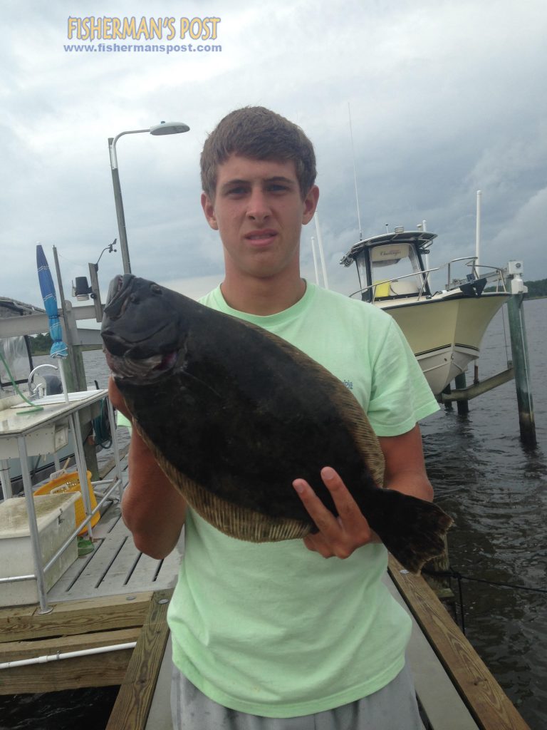 Skylar Johnson with a 20" flounder that struck a 3" Gulp pogy while he was fishing near Dudley's Marina.