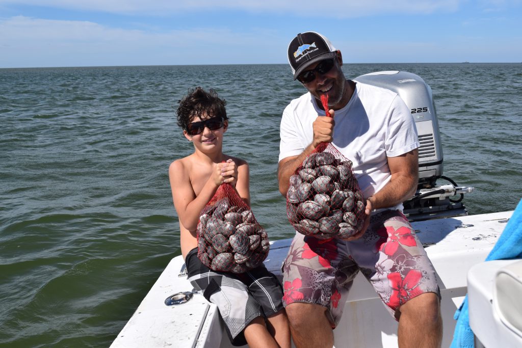 James Hurley and his dad with some of the clams they found shuffling their feet on a shallow grass bed near the Hatteras Inlet. They were clamming (and fishing) with Capt. Joey VanDyke of Outer Banks Charters out of Hatteras Harbor Marina.