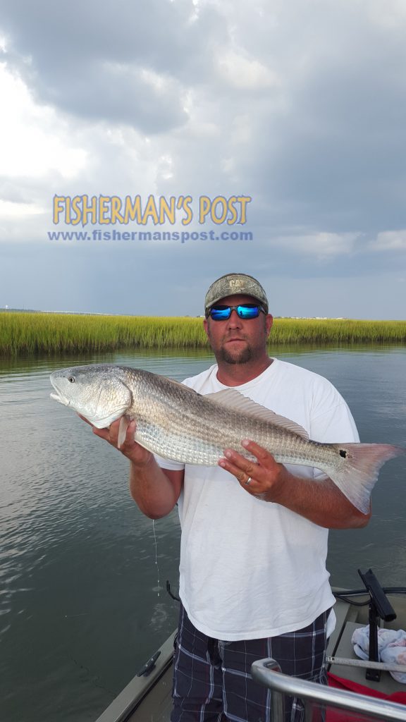 Michael Watts, of Whiteville, NC, with a red drum he hooked near Sunset Beach while fishing with his wife Tracey.